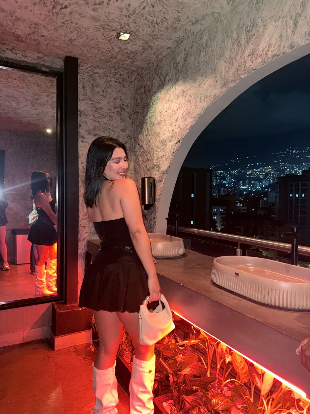 A woman in a dark dress on an evening terrace